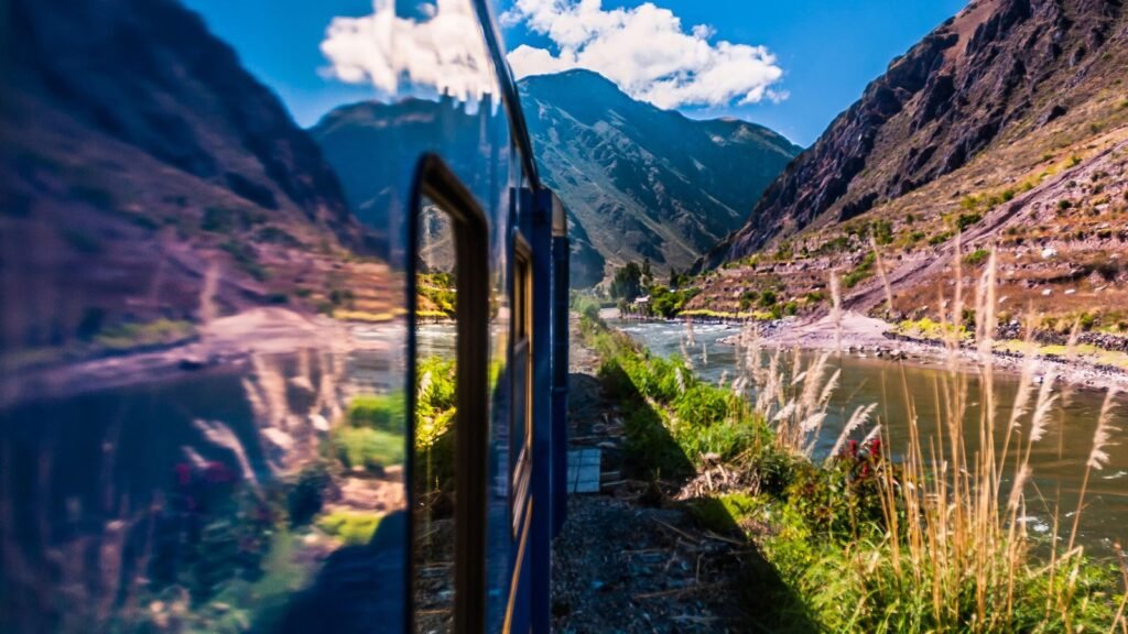 Tren avanzando junto al río Urubamba entre montañas, una de las formas de llegar a Machu Picchu