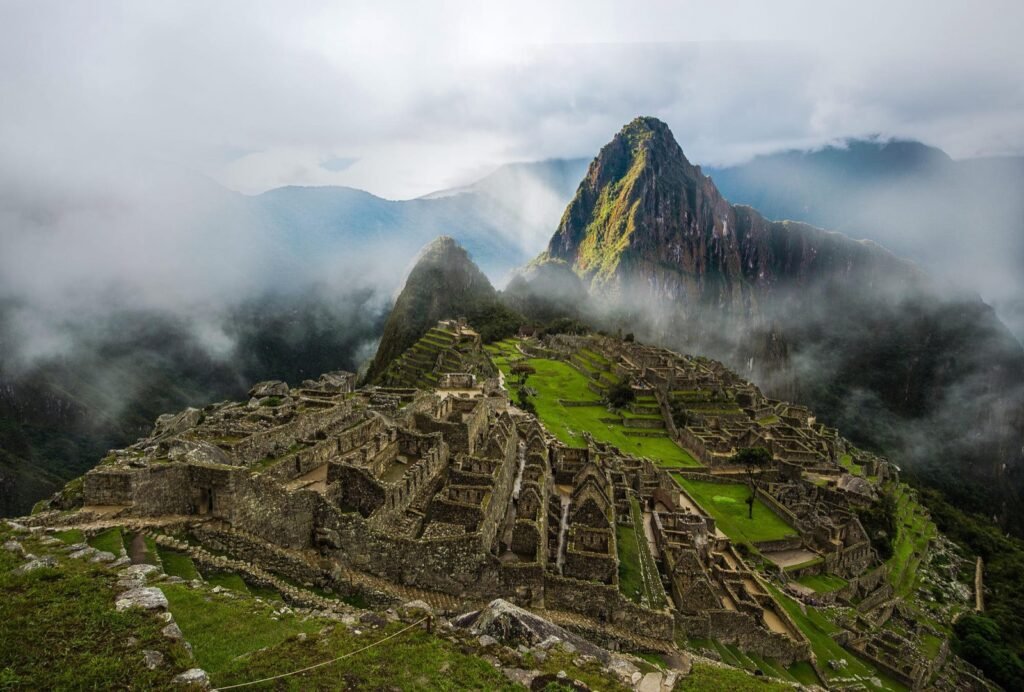 Ciudadela de Machu Picchu entre nubes con la montaña Huayna Picchu al fondo