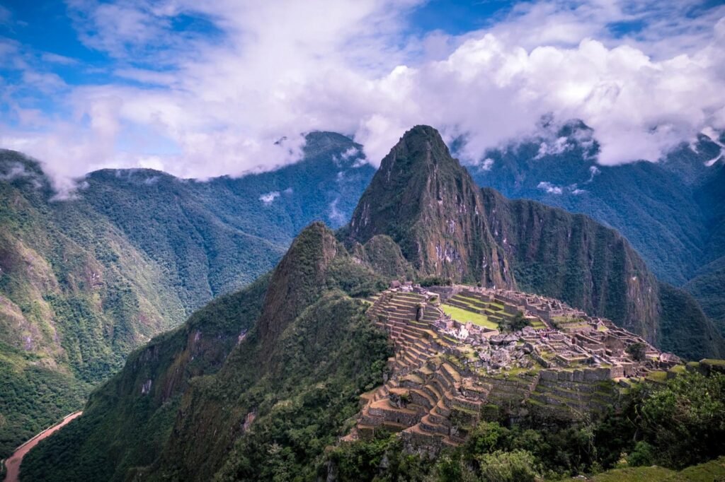 Ciudadela de Machu Picchu con andenes y montañas cubiertas de nubes durante el día