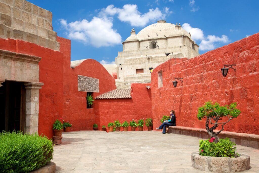 Claustro de muros rojos y cúpula blanca en el centro histórico de Arequipa