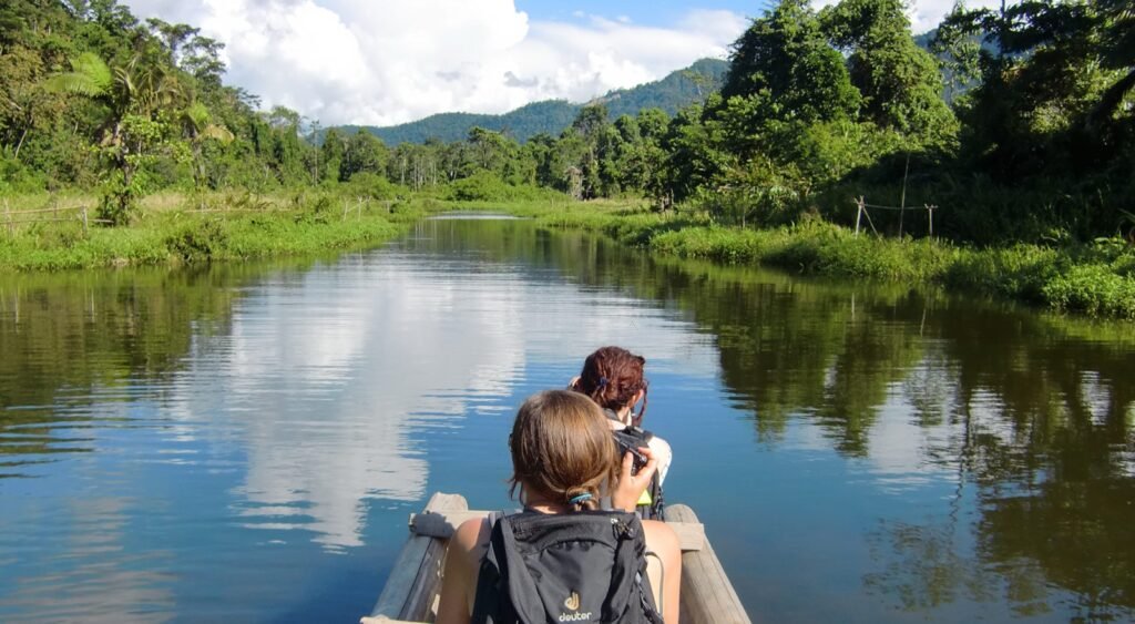 Laguna tranquila rodeada de bosque en la Amazonía peruana, un entorno húmedo donde importa saber qué llevar a la selva