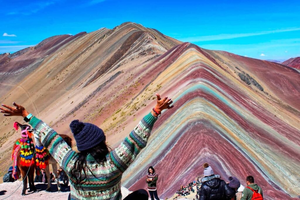 Montaña de Vinicunca con franjas de colores rojizos y verdes bajo un cielo azul
